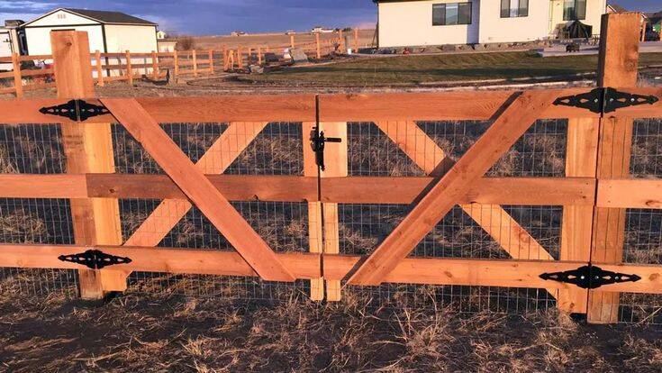 Ranch-style double wood gate with cross bracing at golden hour