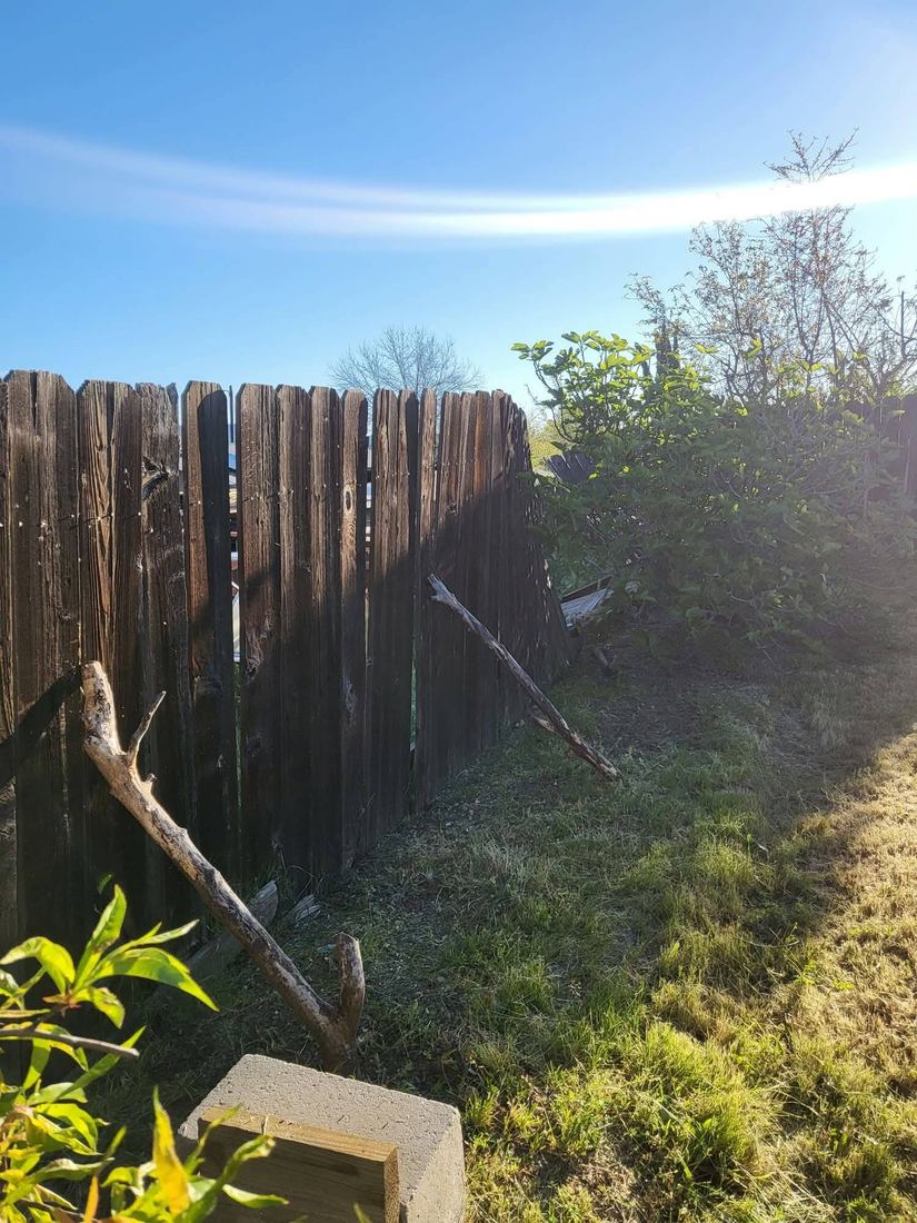Weathered, failing wood fence before replacement